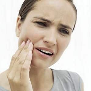 woman with a toothache holding her hand to her jaw